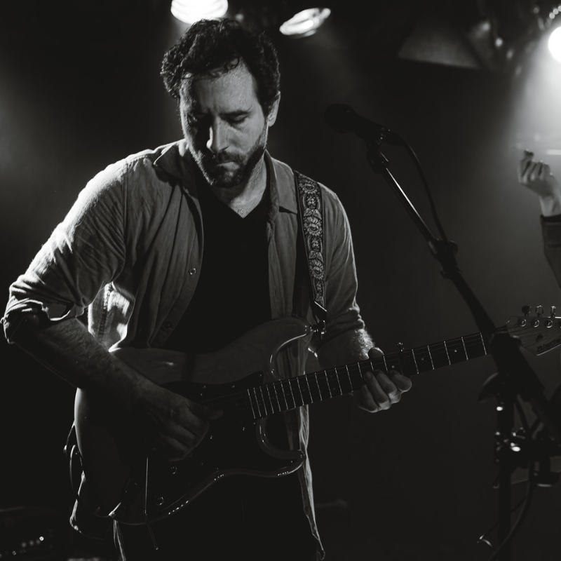Olivier, guitariste-chanteur d’Ol’d Tam, en noir et blanc, concentré sur sa guitare électrique