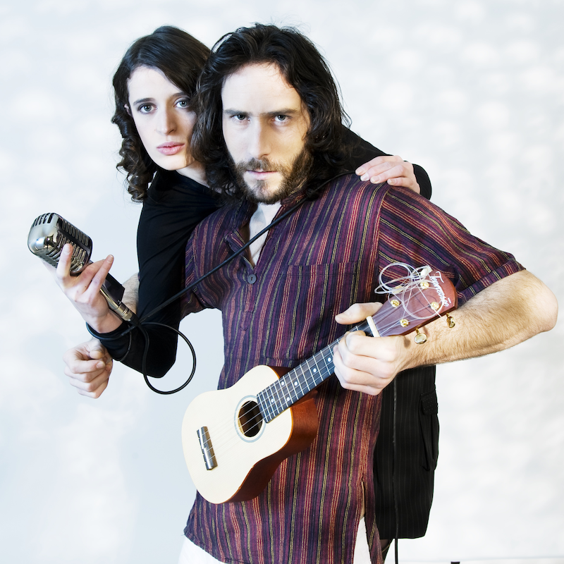 Tamara, chanteuse au micro rétro, et Olivier, guitariste avec un ukulélé, posant avec intensité pour Ol’d Tam, duo Jukebox