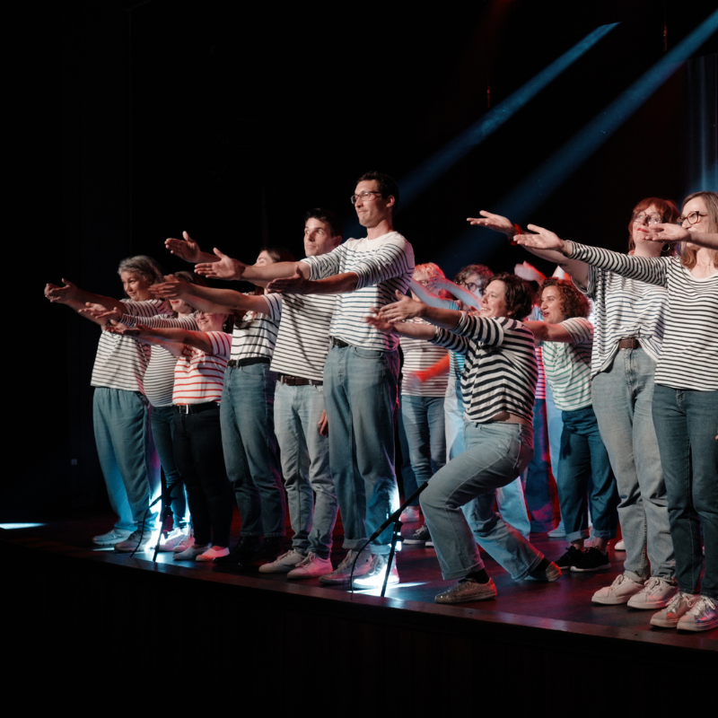 Les choristes de la Chorale Pirate chantent bras ouverts en concert