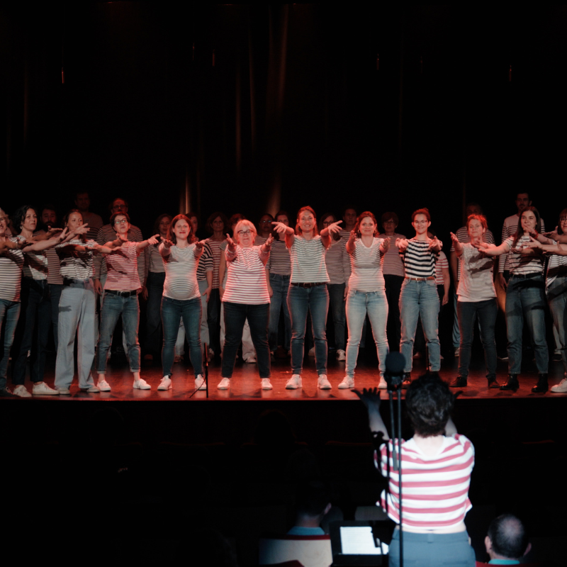 Les choristes de la Chorale Pirate tendent les bras en pleine chorégraphie