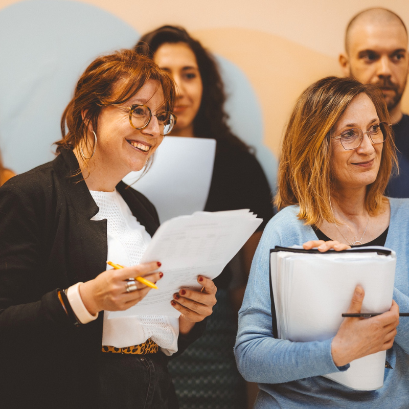 Membres de la Chorale Pirate consultant des partitions pendant une séance de travail.