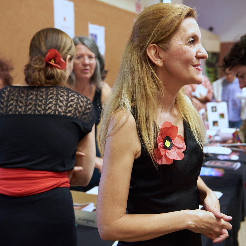 Magali Braconnot, artiste du spectacle Chansons & Coquelicots, hommage à Anne Sylvestre, échange avec une personne après la représentation, devant le stand de C.D.