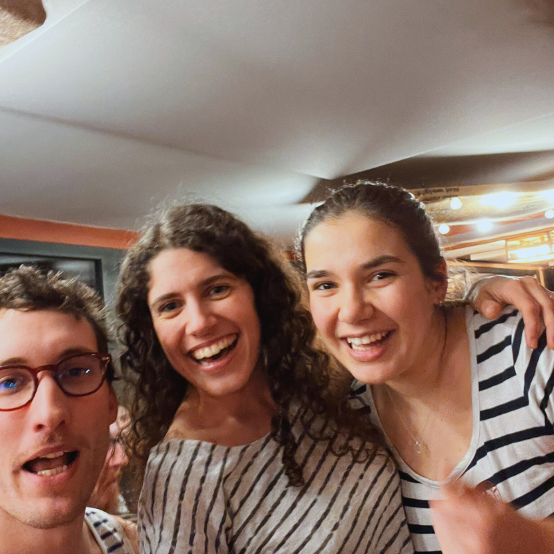 Trois choristes de la Chorale Pirate souriants et enlacés lors d’un moment convivial.