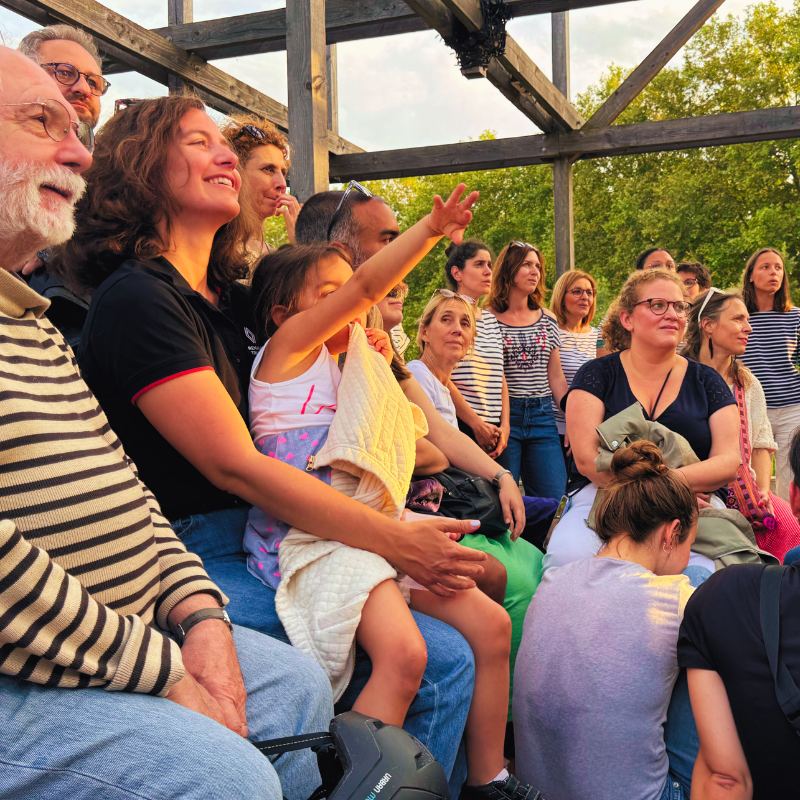 Un public souriant et attentif devant la Chorale Pirate lors d’un concert extérieur.