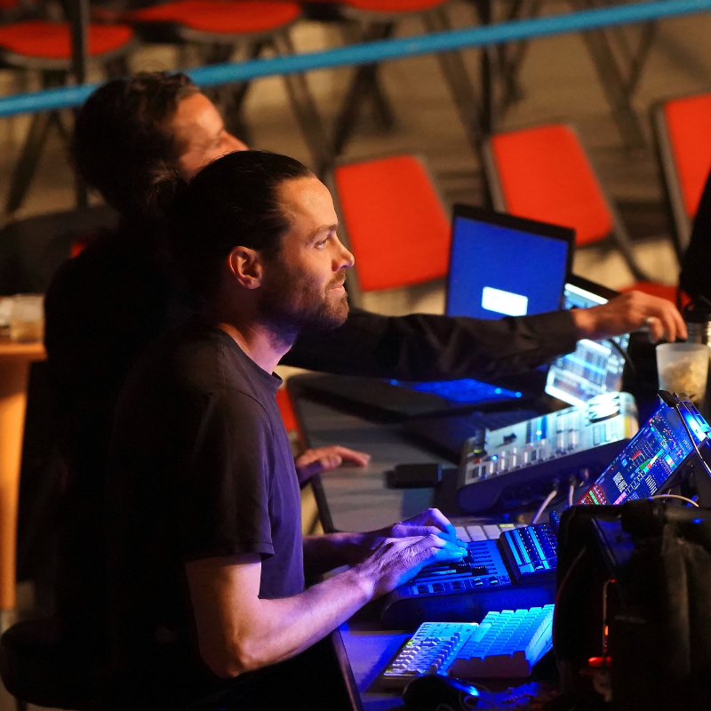 Technicien lumière concentré sur sa console en régie pendant Splendeur & Décadence