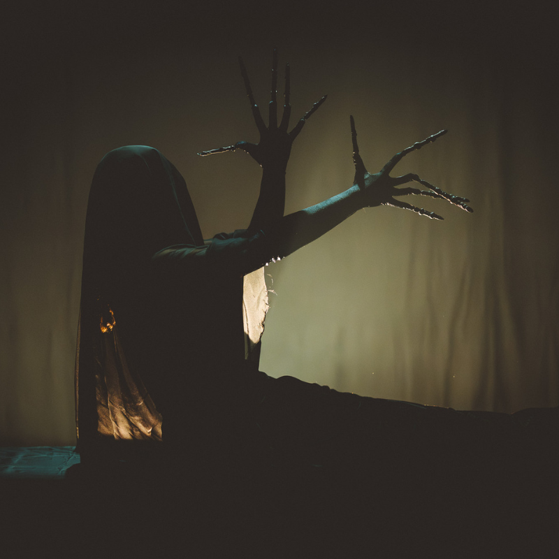 Interprète en silhouette obscure, mains prolongées de longues griffes, dans Splendeur & Décadence