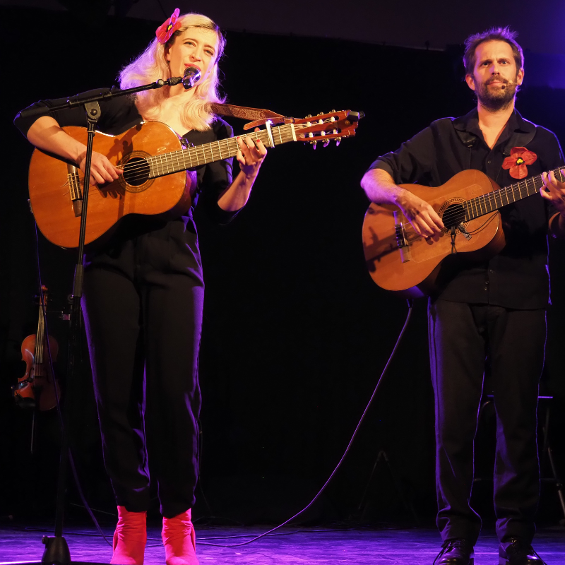 Tamara Dannreuther et Norbert Gautier interprètent à la guitare et au chant la chanson "Mariette et François" lors du spectacle "Chansons & Coquelicots", hommage à Anne Sylvestre.
